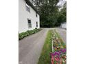 Long driveway flanked by lush greenery and flowerbeds at 5010 Melbourne Rd, Indianapolis, IN 46228