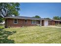 Charming brick home featuring a well-manicured lawn and attached one car garage at 614 Belzer Dr, Anderson, IN 46011