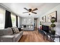 Inviting living room boasts hardwood floors, ceiling fan, and neutral gray colored walls at 614 Belzer Dr, Anderson, IN 46011