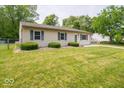 Charming home with a lush front lawn, blue shutters and a fenced in yard to the left at 6408 Old Mill Dr, Indianapolis, IN 46221
