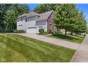 View of the home's side and back exterior and driveway, showcasing the attached garage at 6524 Turning Leaf Ln, Indianapolis, IN 46236