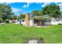 A quaint home boasts a covered front porch, a stone chimney, and a spacious green lawn at 7455 W 700 N, Fairland, IN 46126