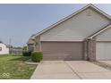 Home exterior featuring attached garage with brick accents and manicured lawn at 824 Ashton Park Dr, Greenwood, IN 46143