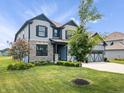 Well-kept home with a lush green lawn, mature trees, and a two-car garage at 8635 Verbena Rd, Zionsville, IN 46077