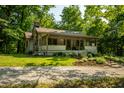 Quaint home featuring a stone chimney, covered porch, and lovely landscaping at 8717 Moore Rd, Indianapolis, IN 46278