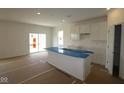Modern kitchen boasts a center island, white cabinets, and abundant natural light from the sliding glass door at 10132 Redwood Peak Ln, Indianapolis, IN 46259