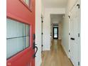 Bright entryway featuring a red front door, sleek hardwood floors, and white trim throughout at 1021 N Alabama St, Indianapolis, IN 46202