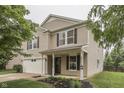 This inviting two-story home features a two-car garage, covered entryway, and colorful front garden at 10510 Mcclain Dr, Brownsburg, IN 46112