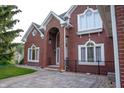 A brick front entrance highlighted by arched windows and a patterned stone walkway to the front door at 1188 Old Eagle Way, Greenwood, IN 46143
