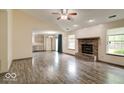 Spacious living room featuring a brick fireplace, wood-look flooring, and ample natural light at 12157 Longstraw Dr, Indianapolis, IN 46236