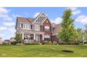 Charming two-story brick home featuring a welcoming front porch and lush lawn at 1313 Brentford Ln, Greenwood, IN 46143