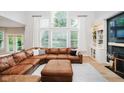 Inviting living room with large windows, leather sectional sofa, and built-in shelving at 14662 Woodstone Cir, Fishers, IN 46037