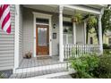 Inviting front porch with a wooden door, decorative plants, and well-maintained railings at 1512 Bellefontaine St, Indianapolis, IN 46202