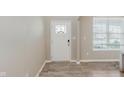 Bright entryway featuring a white front door with decorative glass, neutral walls, and wood-look flooring at 1715 Foudray S Cir, Avon, IN 46123
