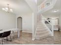 Open foyer with staircase, chandelier, and wood-look flooring, offering a welcoming entrance to the home at 1715 Foudray S Cir, Avon, IN 46123