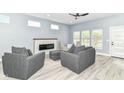 Bright living room with a modern fireplace, ceiling fan, and stylish gray armchairs at 1723 Fletcher Ave, Indianapolis, IN 46203