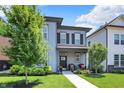Charming two-story home featuring a well-manicured lawn, covered porch with seating and stylish gray siding at 17319 Henslow Dr, Westfield, IN 46074