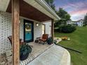 Cozy front porch with brick flooring, chairs, and a teal front door with a wreath at 2015 Deer Lake Dr, Martinsville, IN 46151