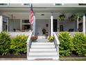Inviting front porch with stairs, landscaping, patriotic decor, and a welcome sign at 22 N Bolton Ave, Indianapolis, IN 46219