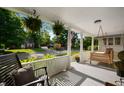 Cozy front porch featuring hanging ferns, a porch swing, and comfortable seating at 22 N Bolton Ave, Indianapolis, IN 46219