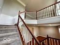 Elegant staircase with wood railing and white spindles, leading to an open foyer and living space at 258 Coatsville Dr, Westfield, IN 46074
