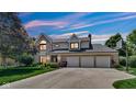 Charming two-story home at twilight with a three-car garage and landscaped yard at 318 Meadowview Ln, Greenwood, IN 46142