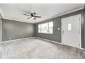 Spacious living room with neutral carpet, ceiling fan, and a large window offering natural light at 3414 Ferncliff Ave, Indianapolis, IN 46227