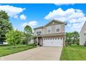 Two-story home featuring vinyl siding, brick accents, a well-maintained lawn, and a two-car garage at 3811 Tartan Trl, Whitestown, IN 46075