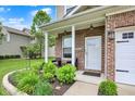 Close-up of the front porch with brickwork, landscaping, and a white front door at 3811 Tartan Trl, Whitestown, IN 46075
