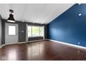Bright living room with vaulted ceilings, hardwood floors, and a large window overlooking the front yard at 4718 Dancer Dr, Indianapolis, IN 46237