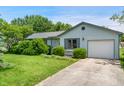 Charming single-story home with light blue siding, an attached garage, and well-maintained front yard at 5380 Collett E Dr, Camby, IN 46113