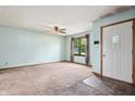 Bright living room with carpeted flooring and a front door with screen, freshly painted walls, and ceiling fan at 5380 Collett E Dr, Camby, IN 46113