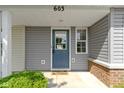 A covered front door with a storm door, brick accents and landscape at 603 Daviess Dr, Westfield, IN 46074