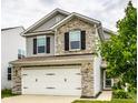 Attractive two-story home featuring stone accents and a white two-car garage at 6114 Pebblebrooke Rd, Whitestown, IN 46075