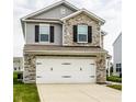 Beautiful two-story home with stone accents and a white two-car garage at 6114 Pebblebrooke Rd, Whitestown, IN 46075