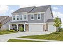 Charming two-story house featuring a three-car garage, complemented by a well-kept lawn and landscaping at 6305 N Woodhaven Dr, McCordsville, IN 46055