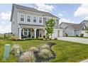 A two-story home with well-maintained landscaping, a spacious lawn, and a welcoming front porch at 6305 N Woodhaven Dr, McCordsville, IN 46055