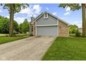 Charming brick and siding home with a well-manicured lawn and a two-car garage at 6518 Springview Dr, Avon, IN 46123