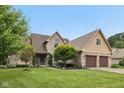 Beautiful home with brick and siding, a two-car garage, lush lawn, and mature trees at 6983 White Oak Dr, Avon, IN 46123
