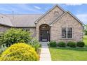 Up-close shot of the home's entry, showcasing detailed brickwork and lush landscaping at 745 Ridge Gate Dr, Brownsburg, IN 46112