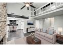 Open-concept living room with fireplace, loft, and view into kitchen at 7507 Choate Ct, Indianapolis, IN 46254