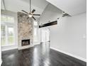 Spacious living room featuring a stone fireplace, vaulted ceilings, and dark hardwood floors at 7507 Choate Ct, Indianapolis, IN 46254