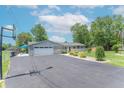 Single-story home with attached garage, manicured lawn, basketball hoop, and American flag at 7850 S Mooresville Rd, Indianapolis, IN 46113