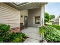 Inviting front porch with seating and colorful flowers, adding a touch of charm and warmth to the entrance at 8223 Thoroughbred Run, Indianapolis, IN 46256