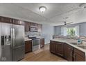 Open kitchen showcasing stainless appliances, modern cabinets and wood-look floors at 9125 Timpani Way, Indianapolis, IN 46231