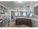 Open kitchen featuring stainless steel appliances, a stylish backsplash and wood-look floors at 9125 Timpani Way, Indianapolis, IN 46231