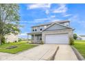 Charming two-story home featuring gray siding, a brick accent wall, and a two-car garage at 9692 Centennial Ct, Avon, IN 46123