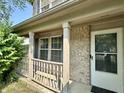 A cozy front porch area with white railing and brick accents on a home's exterior at 10832 Tealpoint Dr, Indianapolis, IN 46229