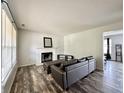 An open-concept living room features modern dark floors, fireplace, and a comfortable brown couch at 10832 Tealpoint Dr, Indianapolis, IN 46229