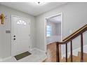 Bright foyer features tile flooring, a coat rack, stairs with wood railing and an interior door with glass at 11461 N College Ave, Carmel, IN 46032